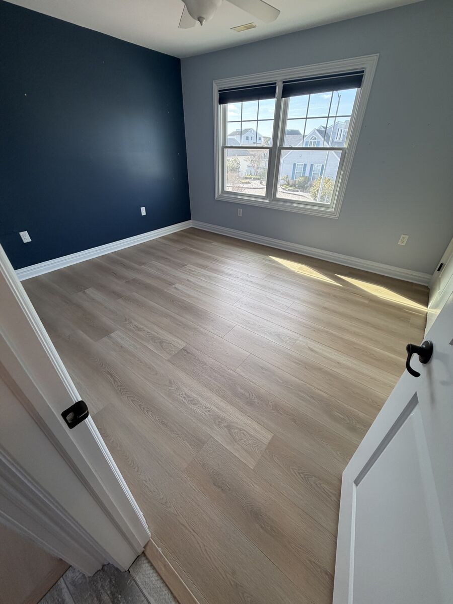 Bedroom with navy accent wall and finished hardwood floor