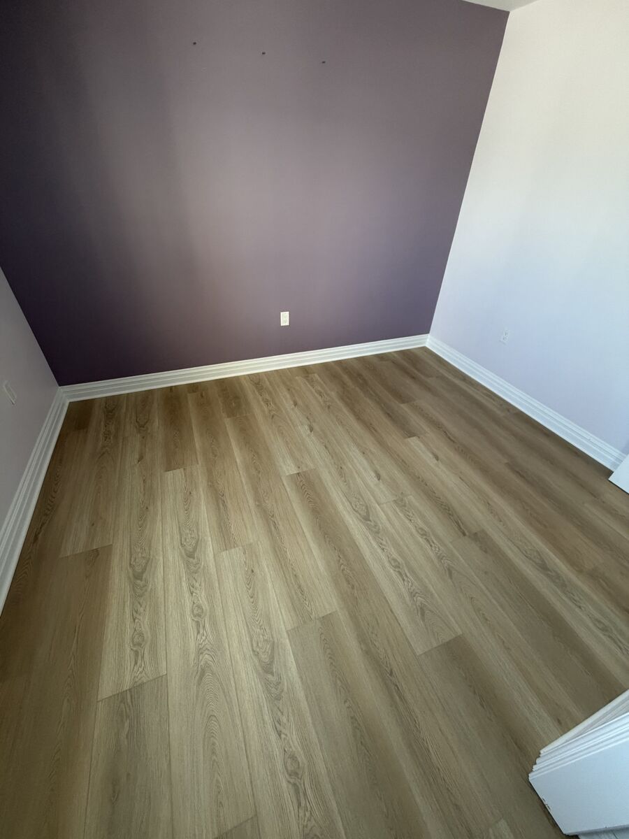 Bedroom with purple accent wall and finished hardwood floor