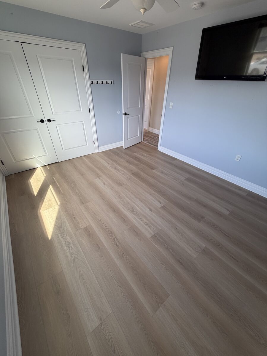 Bedroom with TV wall and finished hardwood floor
