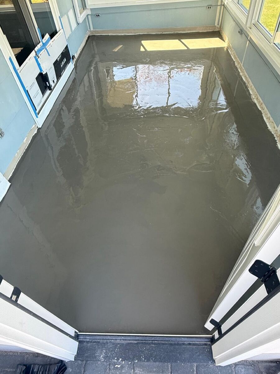 Self-leveling compound poured to prep a sunroom subfloor before installation