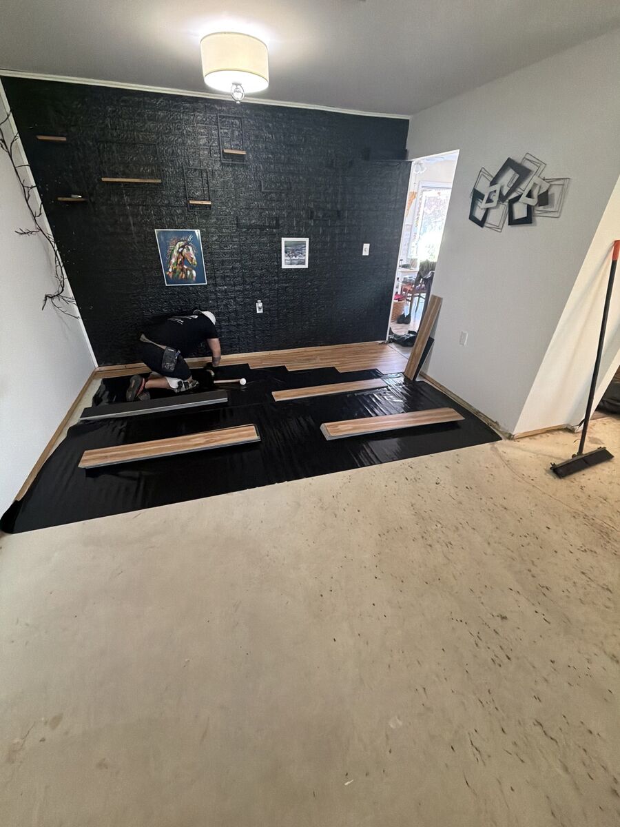 Vinyl plank flooring being laid piece by piece during an active installation