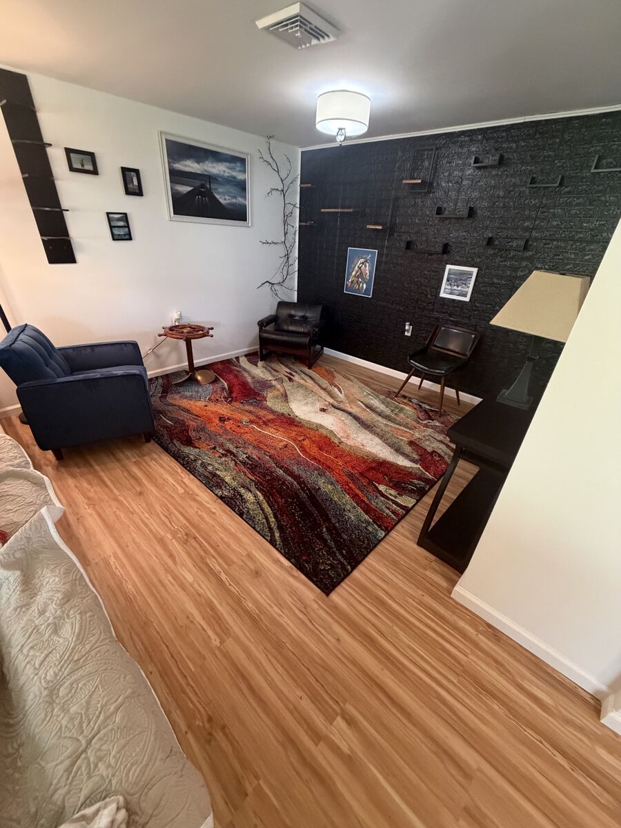 Living room with area rug over finished hardwood floor