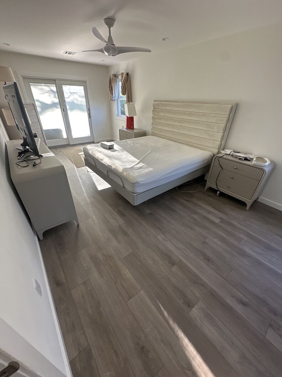 Finished hardwood floor in a primary bedroom